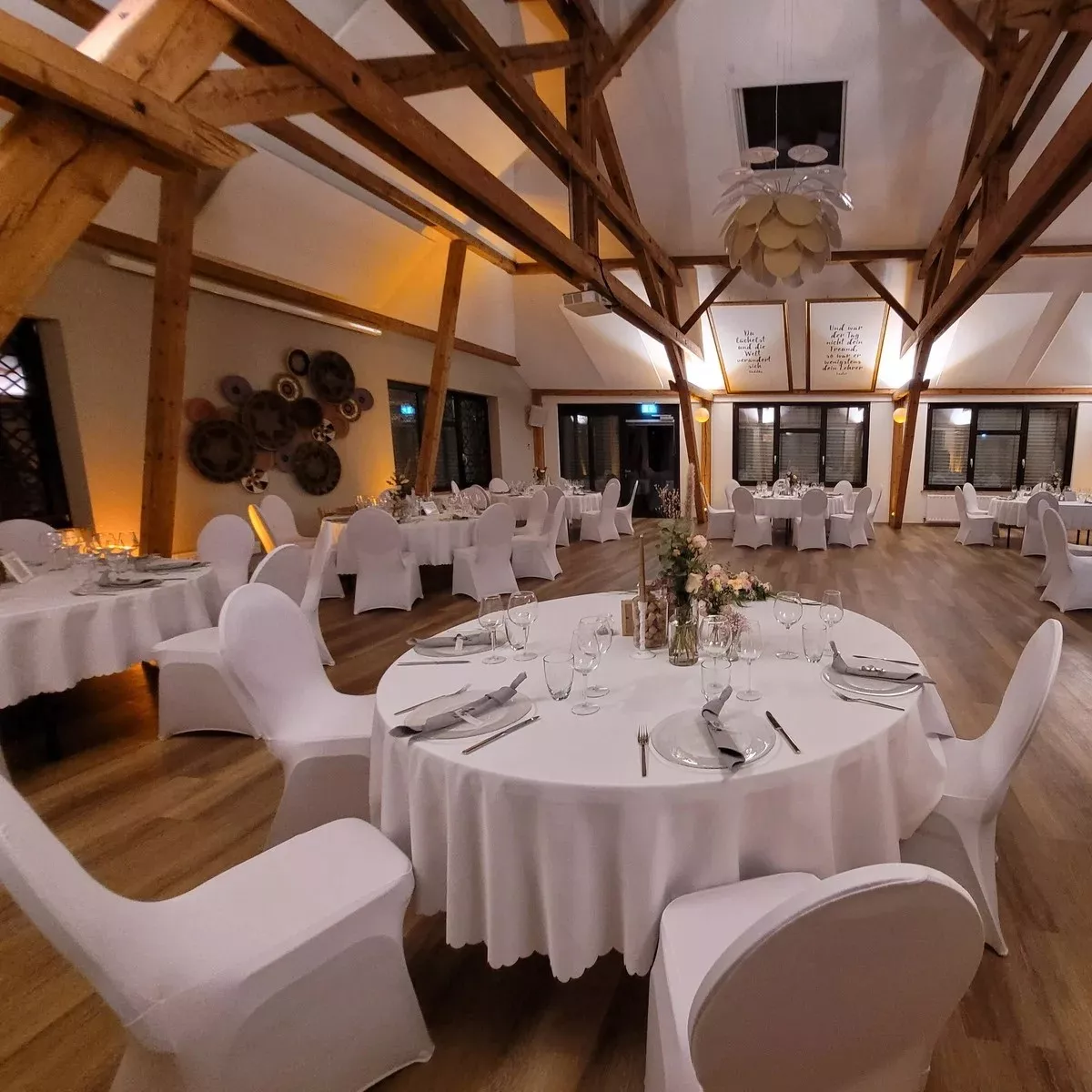 Gemieteter Raum mit weiß gedeckten Tischen von einer Hochzeitsveranstaltung Hochzeitstag Partylocation